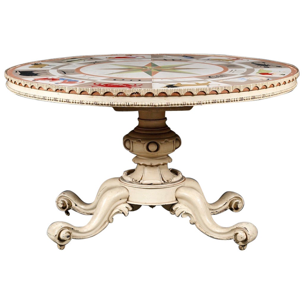 An interesting carved and painted 19th century center table decorated in the Art Deco period with zodiac design top.

The top with polychrome painted wheel of the zodiac with central compass motif, the edge with arcaded frieze and bead molding.