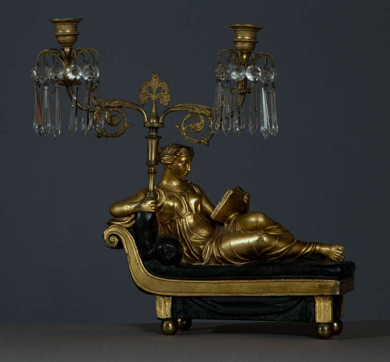 Each in the form of a reclining Classical figure supporting two-light scrolling candle arms adorned with prisms.  Detailed research report available on request.