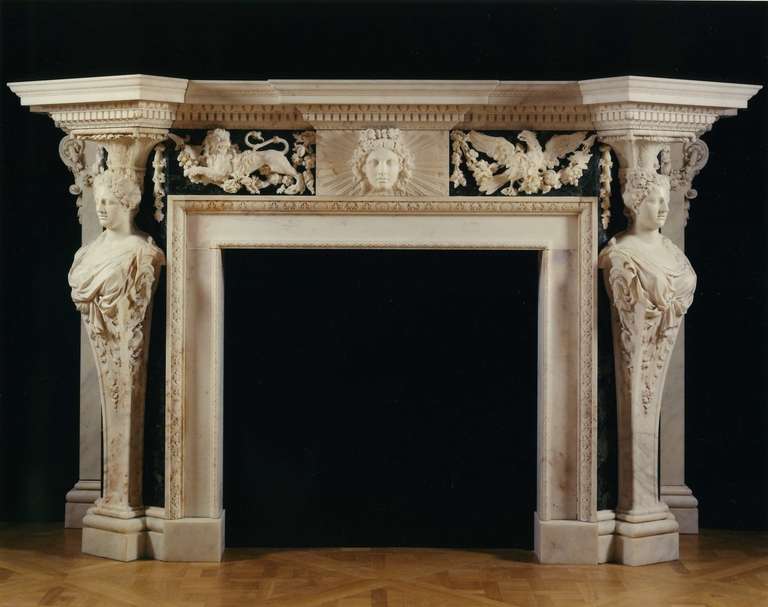 Each surmounted by a projecting shaped shelf above boldly carved  tongue and dart and dentilled moldings, the breakfronted frieze centered by a plaque carved with a mask of Apollo surrounded by a sunburst, the plaque flanked by a rampant lion to one