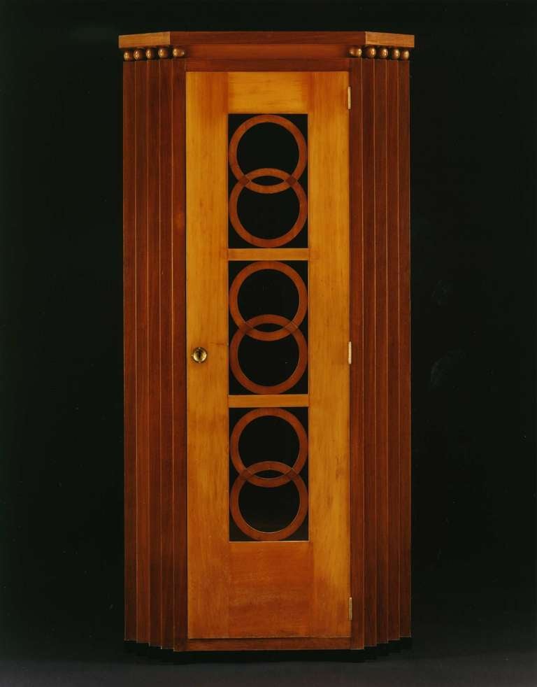 The shaped top raised on two rows of spheres, the cupboard door with three pierced panels filled with interlinking circles, the door opening to reveal an interior fitted with shelves, the door flanked by the stepped angles. Detailed condition report