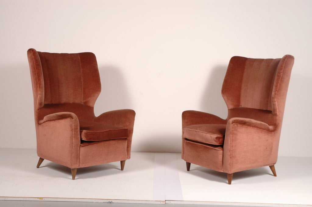 Magnificent pair of Gio Ponti High back arm chairs,beautifully upholstered in it's original apricot velvet, walnut legs.Very comfortable.