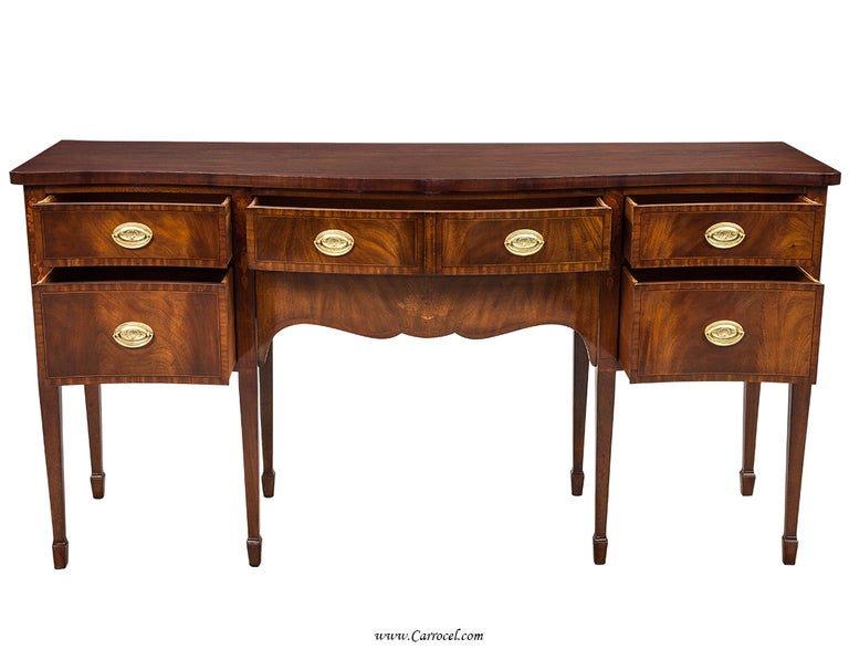 What a gorgeous piece this is!  Made in the early 20th century by true American craftsmen, this English inspired sideboard has been magnificently restored by our master artisans to its original beauty.  Featuring expertly picked crotch mahogany