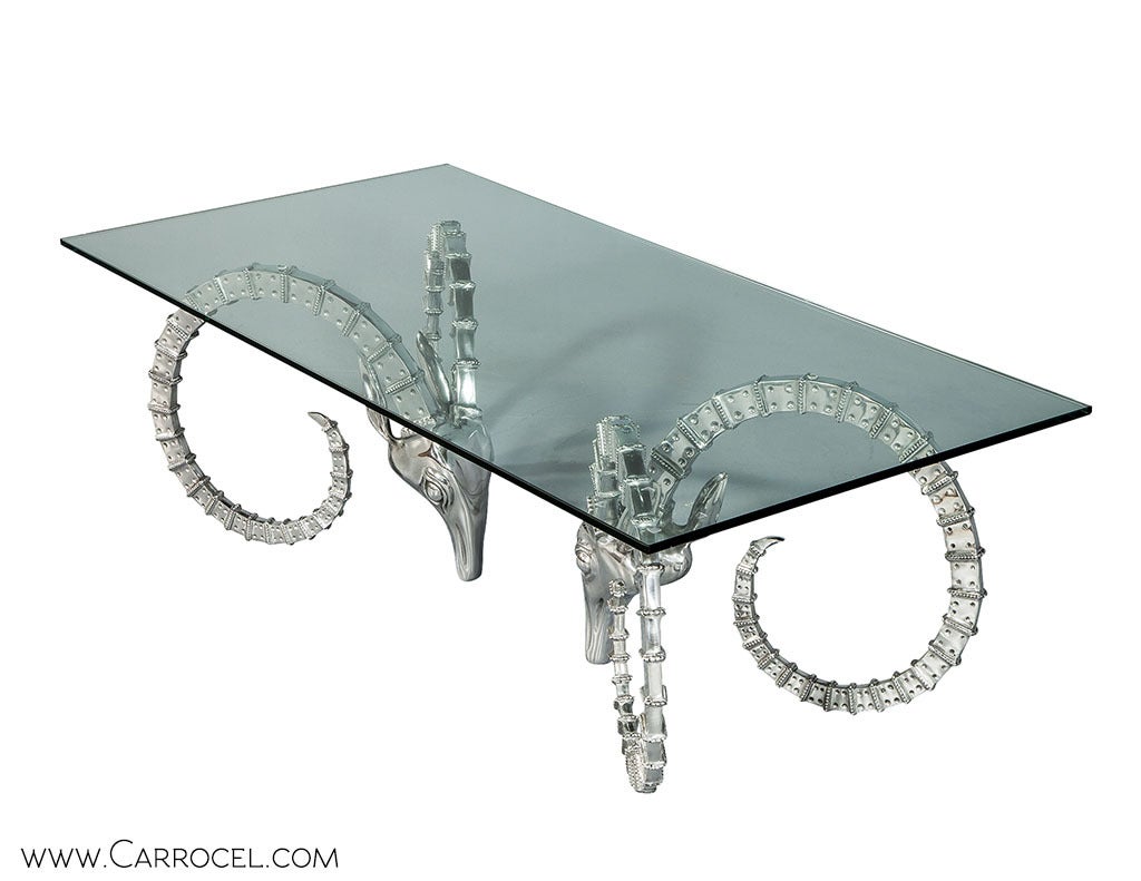 Two rams head pedestals support a floating glass top in this modern version of a classic cocktail table design.