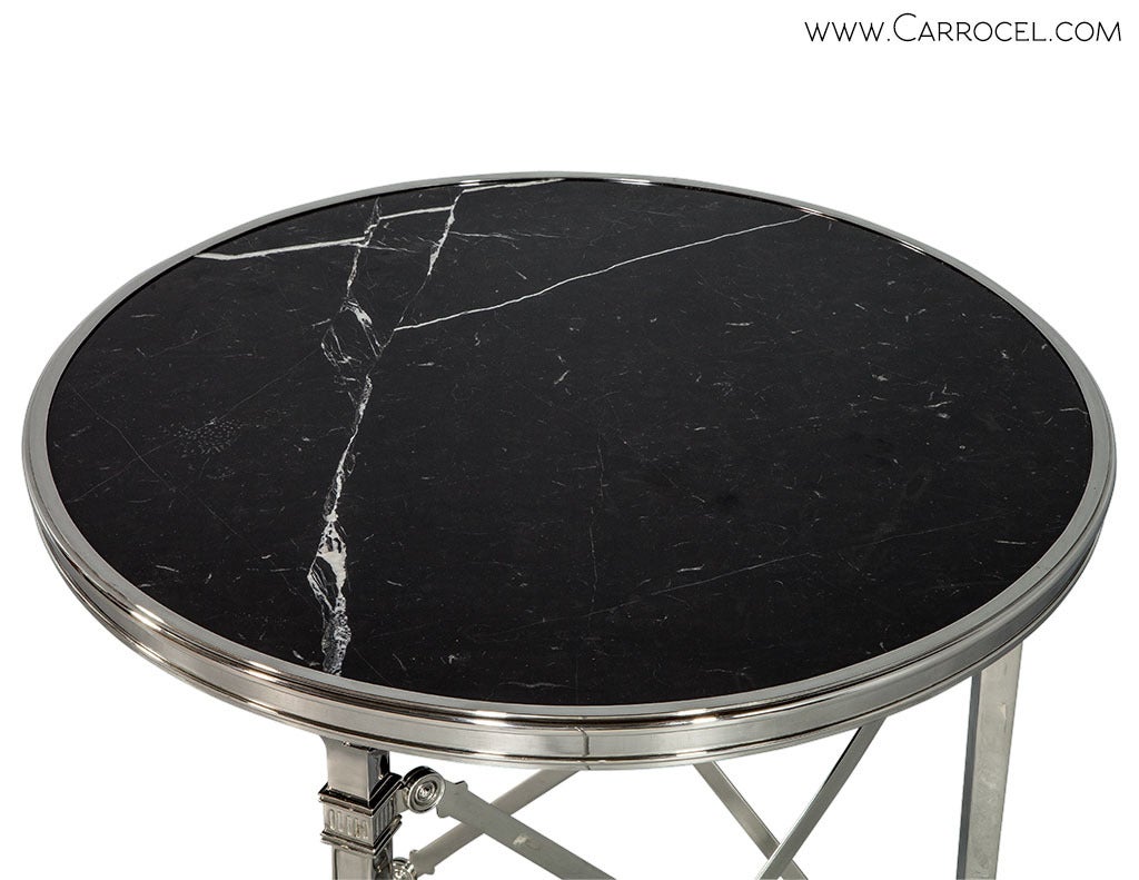 Classic gueridon table with inset polished black marble top.  The base consist of three legs with animal paw feet in polished nickel.