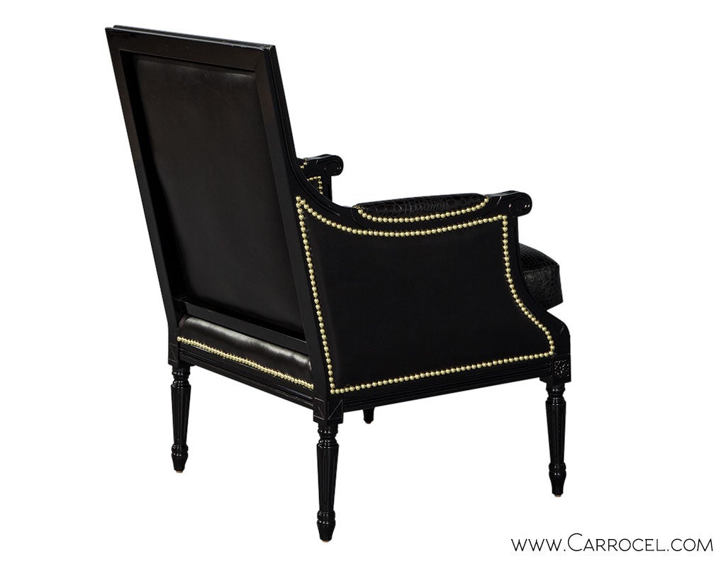 Stunning Louis XVI bergere lounge chair custom finished in high-gloss black. The frame interior is upholstered with embossed croc motif leather. The exterior is upholstered with supple black leather, accented by gold nail head trim. Customize this