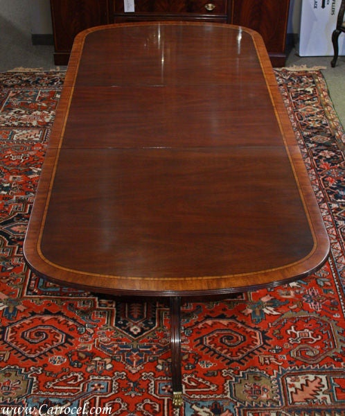 This listing is for a mahogany dining table made by the one of America's finest furniture manufacturers, Henkel Harris of Winchester, Virginia. It is a double pedestal Duncan Phyfe table with a revers matched cathedral figured mahogany veneer top
