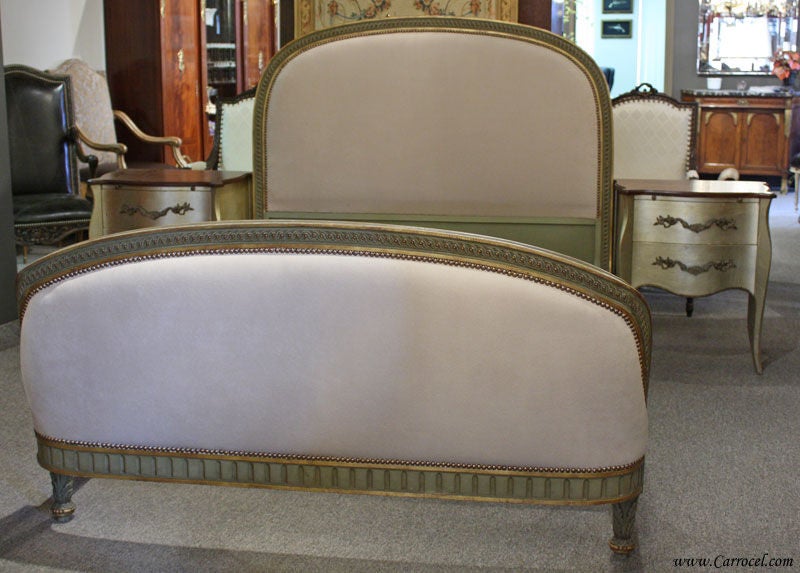 This is an antique French Louis XVI double headboard and footboard. It is in its original condition except for the upholstery, which has been redone in a sleek beige linen. The footboard is beautifully curved in a design made to hug the mattress for