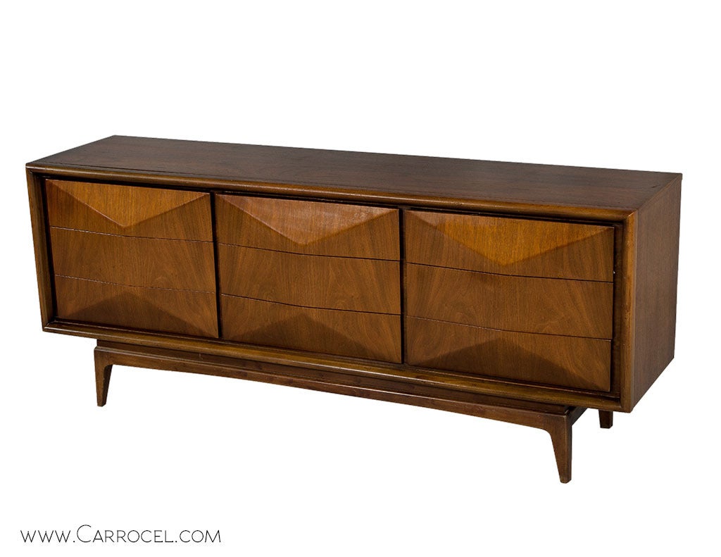 Sleek, classic, modern, Mid Century walnut three-dimensional diamond front credenza attributed to Vladimir Kagan. The nine drawers provide ample storage functioning perfectly as a bedroom dresser or credenza. This piece is in good original condition.