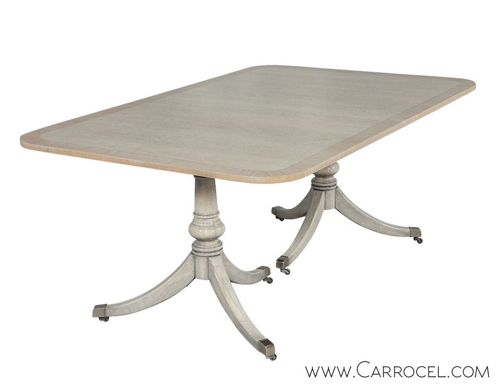 Mahogany dining table revived and modernized with a custom Carrocel aged white finish. The natural wood tone has been lifted and stained a nude tone then buffed to a shining patina. The two Duncan Phyfe style pedestals have gone through a similar