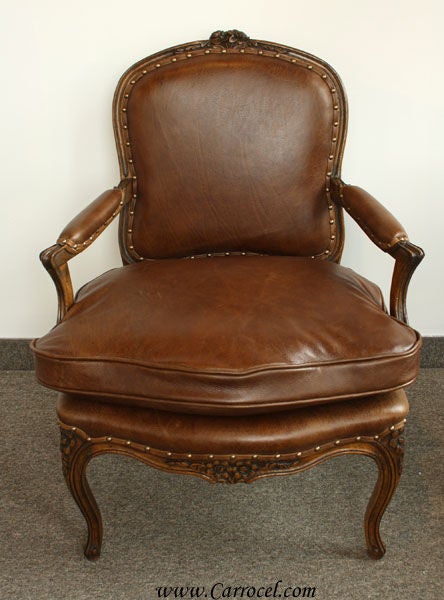 Here we have an antique French country solid walnut leather arm chair that has been professionally stripped, repaired, re-glued, reinforced, and refinished in a classic country walnut and upholstered with new Italian leather and topped off with