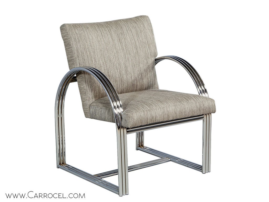 Slick and unpretentious in the trademark Milo Baughman way, this set of two armchairs features a curved metallic frame coupled with earthy fabric cushioning. The original frame in polished chrome brings in a whole new level of class. The angle of