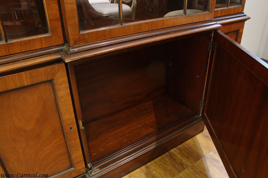 This beautiful mahogany 1940s china cabinet is made by Kittinger.  It features Honduran mahogany with lovely latticework on the doors that open to reveal solid wood shelving with custom plate grooves.  The buffet section has plenty of storage space
