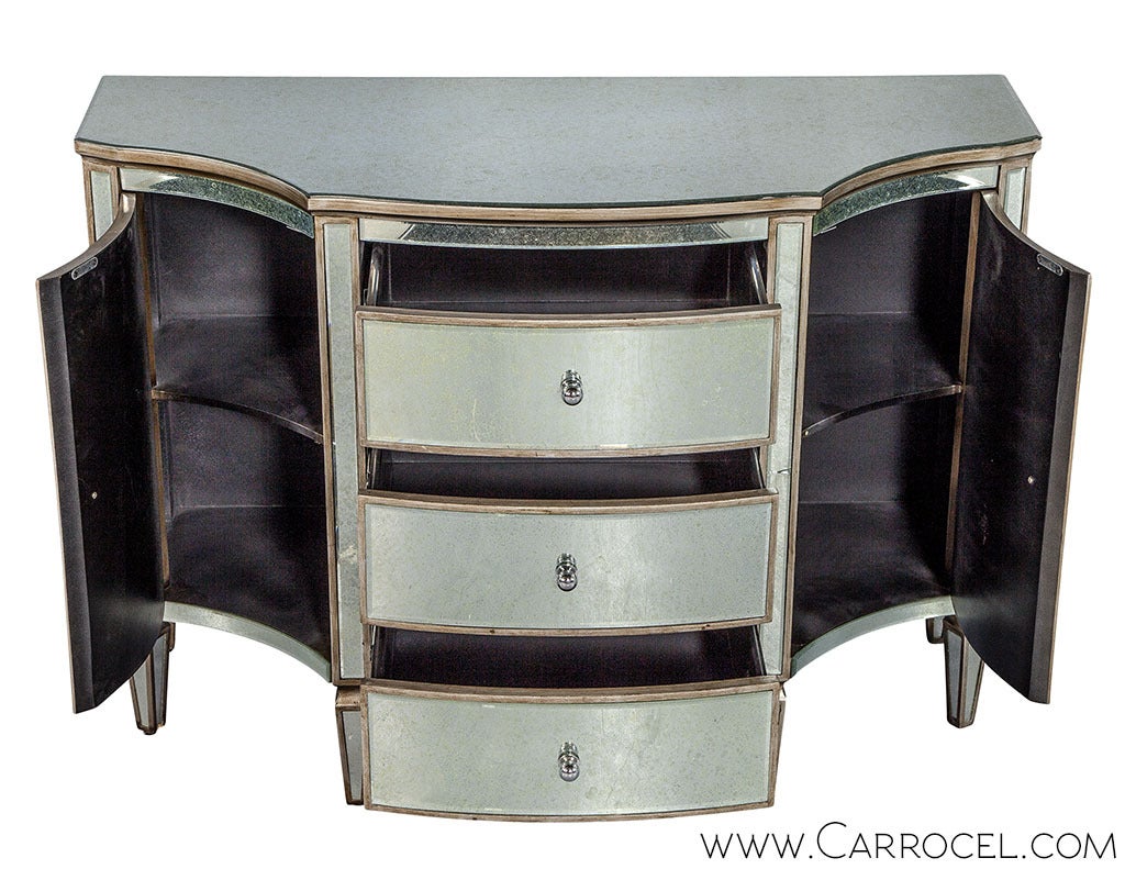 Get yourself the perfect accent piece for a little glamour in your living room. This distressed mirror console commode features a classic symmetric design consisting of a serpentine style, with a bowed front and concave sides. Drawers in front and