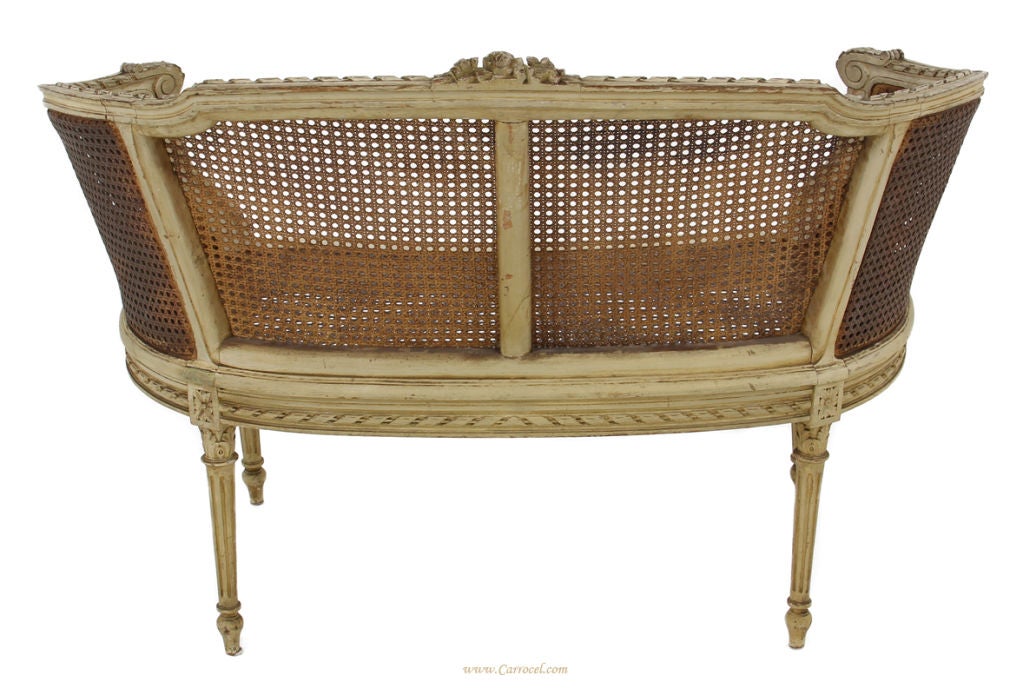 This is a gorgeous little settee bench!  Made in the early 20th century in NY, it features hand-carved classical French floral detailing and a double caned frame - all in original condition and without any breaks.  It has been made in a hand-applied