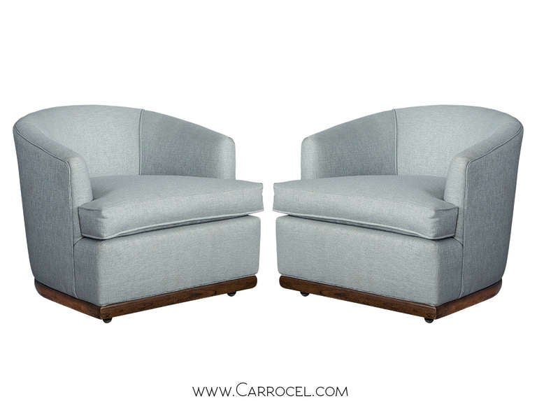 Pair of mid-century modern barrel chairs reupholstered and restored in a designer shimmery blue woven fabric, featuring a walnut base.
