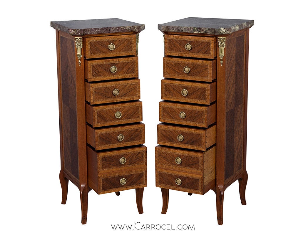 Sleek proportions, a purple marble top and graceful cabriole legs constitute this pair of Louis XVI style lingerie chests from makers Slack-Rassnick & Co. High on the space quotient thanks to seven drawers, and replete with the elegance of original