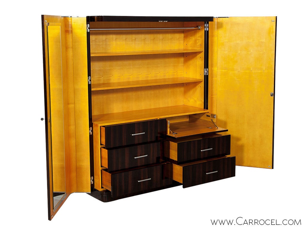 A stylish wardrobe from Ralph Lauren, which combines the characteristic proportions of Art Deco furniture with a modern organization. A fascia of rich Macassar ebony veneered double doors with stainless steel knob handles, covers a spacious interior