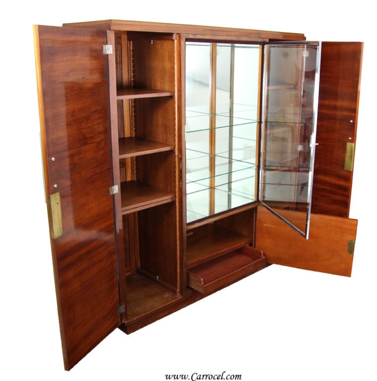 Made in France in the 1930s/1940s, this absolutely stunning Art Deco cabinet features the finest flamed mahogany construction, gorgeous mahogany solids, original glass door and shelves, as well as radiant chrome hardware.  This is a piece that you