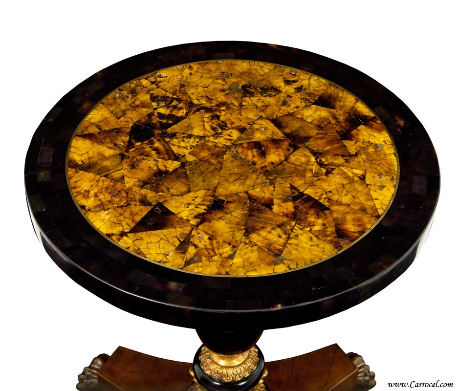 This beautiful round end table was made by EJ Victor in North Carolina.  It features a highly detailed tortoise shell patterned top and hand-placed gilding on an ebonized pedestal column.  The base is adorned with rich leather complete with