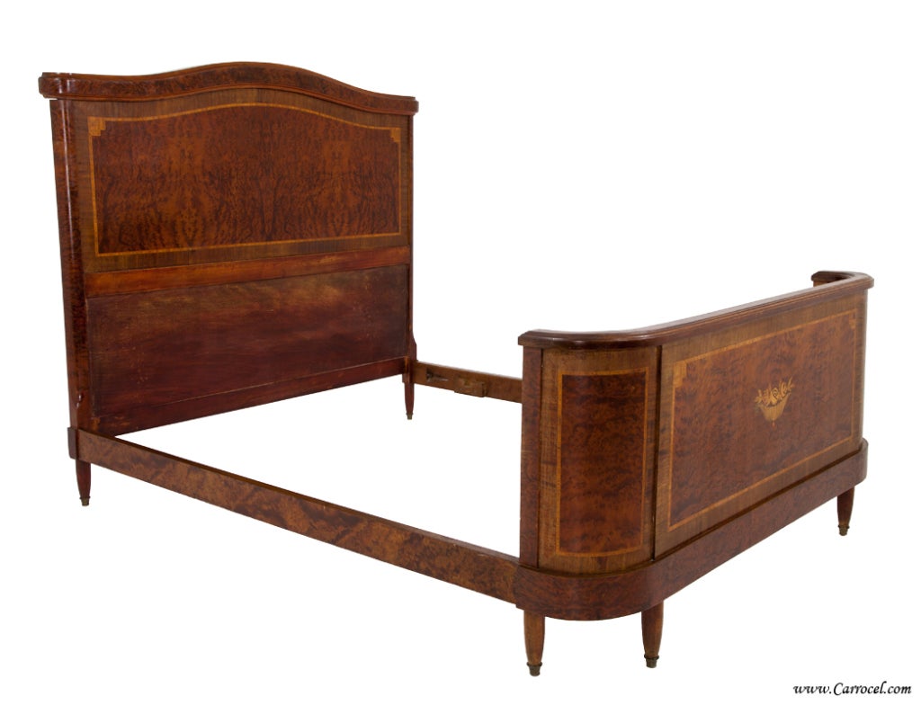 Here we have an antique DOUBLE bed.  Made in France in the early 20th century, it is adorned with beautifully cut burled walnut throughout along with a combination of various other exotic woods making up the floral inlay and banding.  It is in very