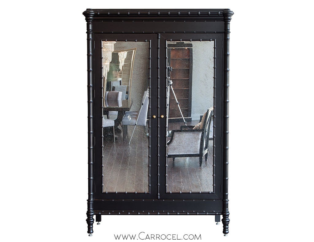 Designed by Julia Gray Faux Bamboo armoire entertainment cabinet. Finished in a classic black satin lacquer with faux bamboo appointments this armoire complements a traditional or modern setting. With distressed mirror doors that fold out 180