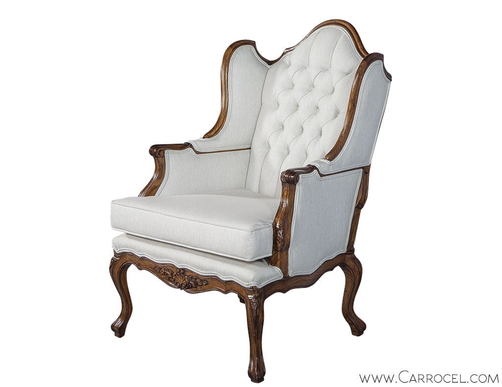Lounge in style with this charismatic hand carved wingback chair from the Carrocel Revival Collection. An antique Louis XV mahogany frame with sharply curving sides, fluted arms and carved cabriole legs. Newly restored with all new upholstery