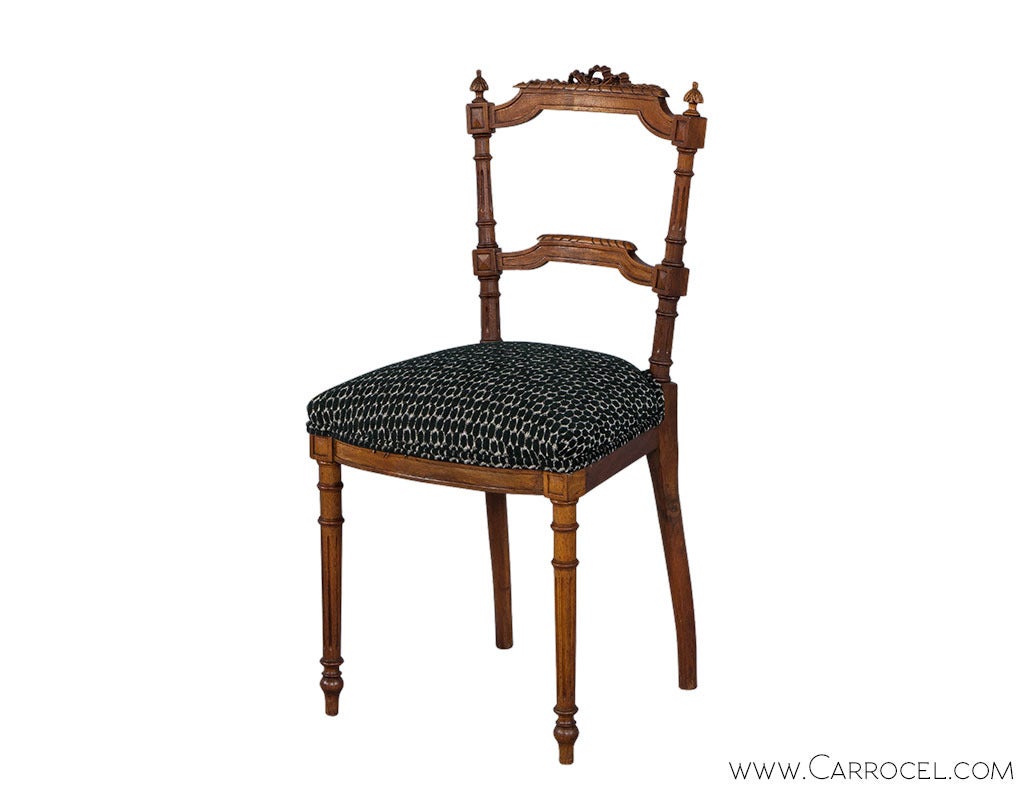 Two vintage Louis XVI accent chairs with all the hand carved glory of the Rococo styles. Trapezoid seats with new upholstery, gently curved fronts, parterre knees and fluted legs terminating in arrow feet, are complemented by gracefully carved slat