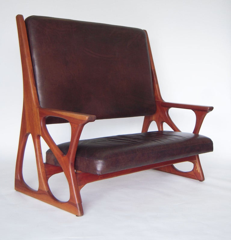 Superb 1960s American studio handcrafted walnut and mahogany wood settee or bench in organic sculpted-form sides and base upholstered in Buffalo leather. In the manner of Phillip Lloyd Powell.

Comfortable low seat perfect for an eclectic office
