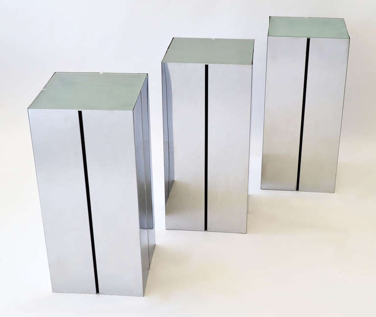 Matching set of three chrome pedestals with frosted glass shelves, inset black strip, designed by Neal Small for Kovacs.