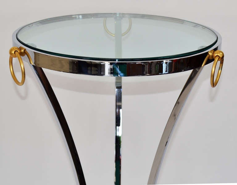 Mid Century Pedestal in Chrome Glass and Brass by Maison Jansen. Three-legged tall pedestal table in polished chrome and glass with hooved feet, finished with decorative brass rings on the rim. Beautiful thick crystal glass insert.
