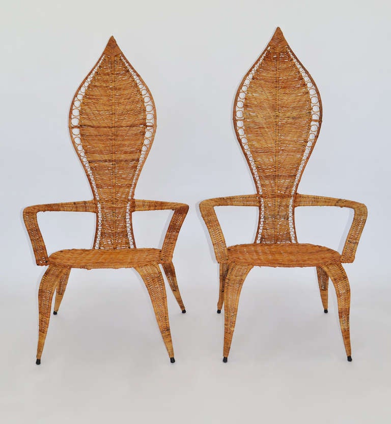 Pair of shield-back fan armchairs in woven rattan over painted steel frame.