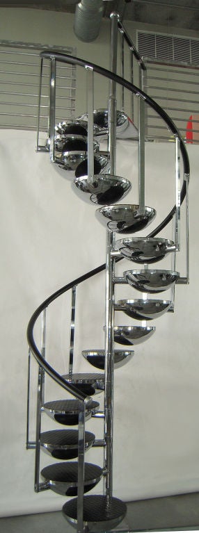 Sculptural staircase, made of a steel center pole where hemispheres are suspended and serve as steps. Chrome finish on the entire structure, for the exception of the handrail that is ebonized urethane. Black rubber industrial treading cover the