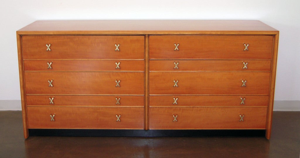 A 1950s California Modern Paul Frankl dresser or chest of drawers in bleached mahogany on a black plinth base with ten drawers and original brass X-pulls. Professionally restored. Johnson Furniture Label.