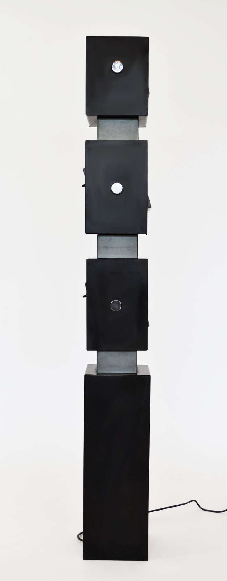 3-light adjustable totem-style floor lamp in enameled steel 
designed by Irving Richards for Arteluce. 3 individual-switch lamps swivel on both horizontal central axis and vertically as individual spots. Impressed covers 