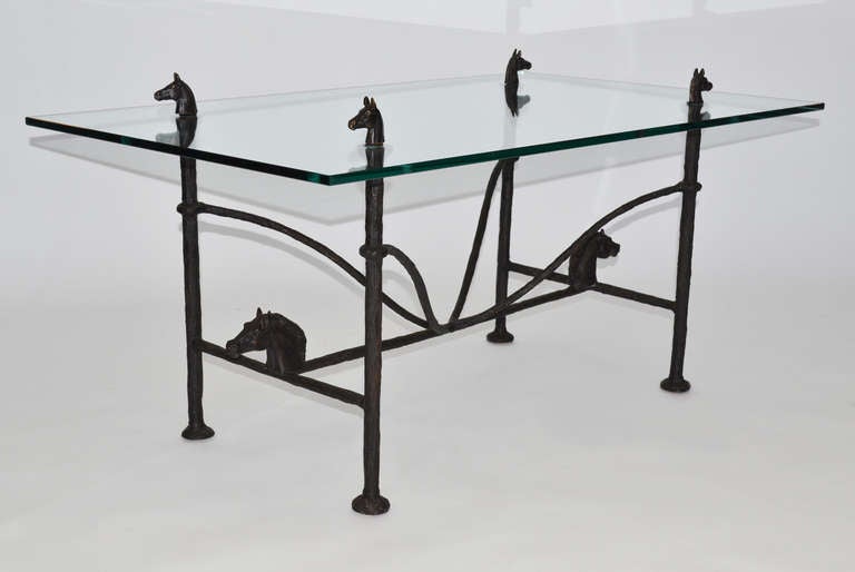 Patinated bronze and glass coffee table by Christopher Chodoff, New York, 1970's. Giacometti-inspired sculpted bronze table with through glass horse head finials and horse head decorations on base. Signed.