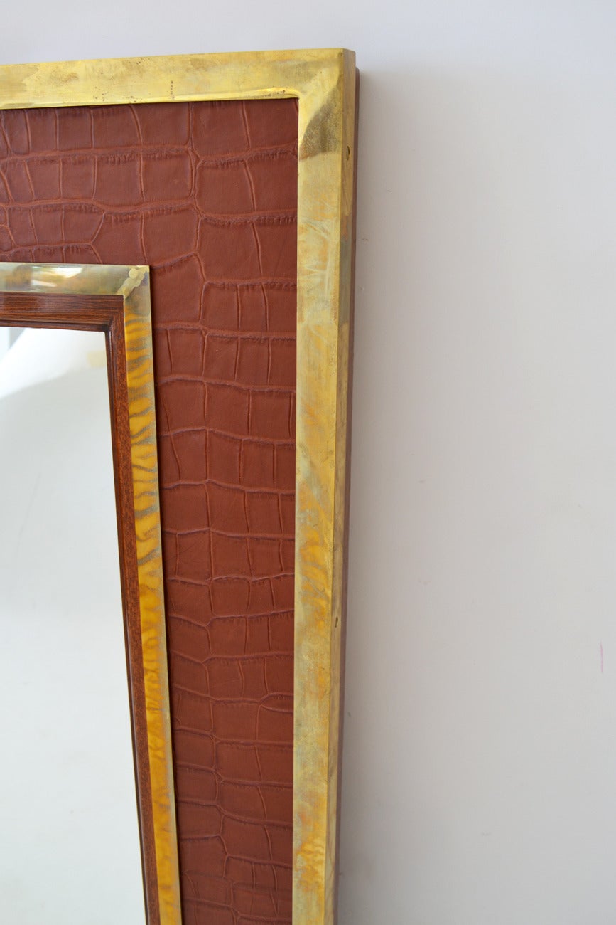A finely detailed, mixed-materials Ralph Lauren home mirror in deep brick alligator-embossed leather rimmed in brass and mahogany. Equestrian-themed, oversized, of sturdy construction. Nicely patinated brass. Labeled.