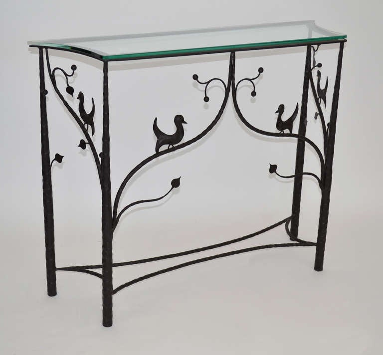 Slender and elegant console table in forged steel depicting tree branches with birds. Unique geometric form top, covered in glass.