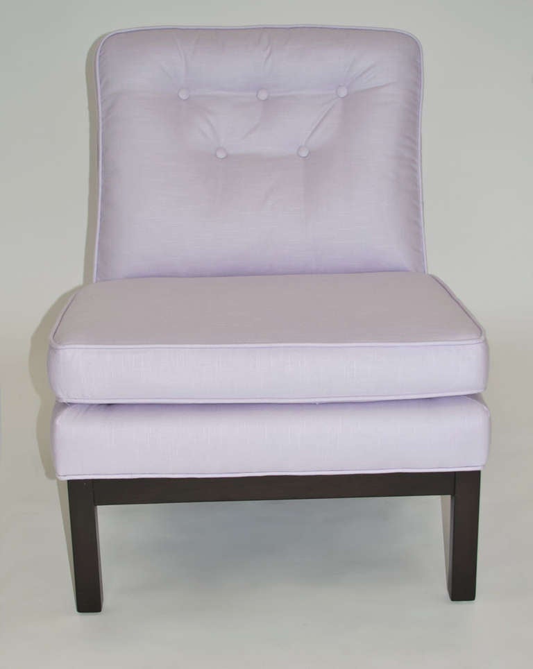 Classic pair of low Mid-Century slipper lounge chairs in the style of or after Harvey Probber. Newly upholstered in a fabulous pale lilac-colored cotton/linen fabric with a professionally restored dark finish walnut base.