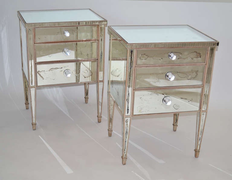 Pair of original 1940's French night stands or end tables with three drawers on tapered legs, in a light wood finish covered in mirror and naturally aged with the years. Lucite pulls.