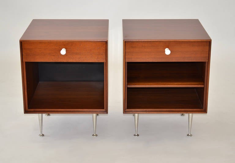 Walnut double nightstands with single drawers on metal legs.