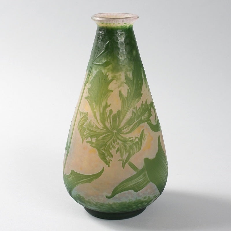 A French Art Nouveau wheel-carved cameo glass vase by Daum, featuring light green flowers and leaves on a pink and orange marteléd ground. Circa 1910.

Signed, “Daum Nancy” with the Croix de Lorraine. 

A vase with similar decoration is