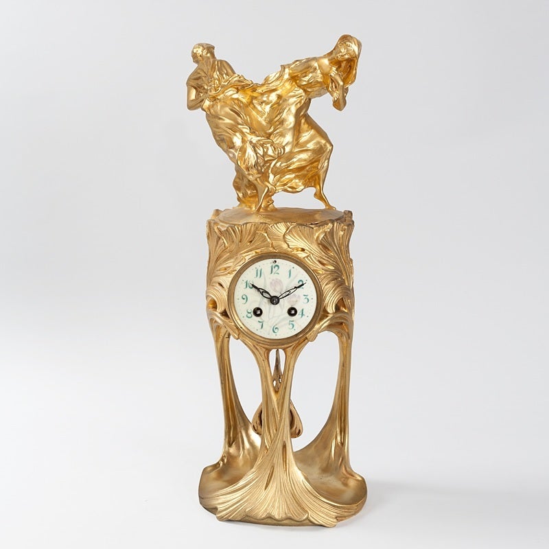 A French Art Nouveau clock in gilt bronze by Maurice Dufrène with dancing figures modeled by Félix Voulot for the Parisian atelier La Maison Moderne, circa 1900. 

A similar model of this clock is part of the permanent collection of the Museum fur