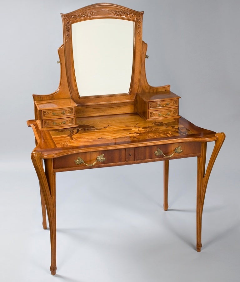 A French Art Nouveau vanity by Gauthier, featuring inlaid marquetry depicting a natural landscape scene. The intricately carved vanity is further enhanced by original bronze drawer pulls in a floral motif.

(MG #11948)