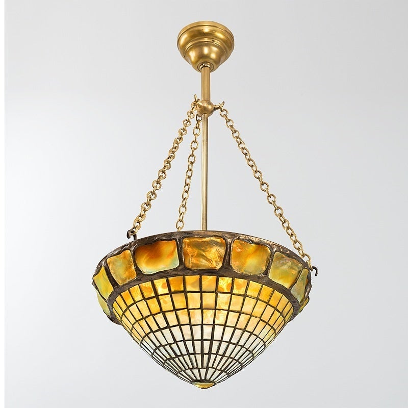 A pair of Tiffany Studios New York glass and bronze “Turtleback Tile” chandeliers, featuring a turtle back band and graduated white to mottled-yellow Favrile glass squares in concentric circles, culminating in a single dimensional “Turtleback” glass