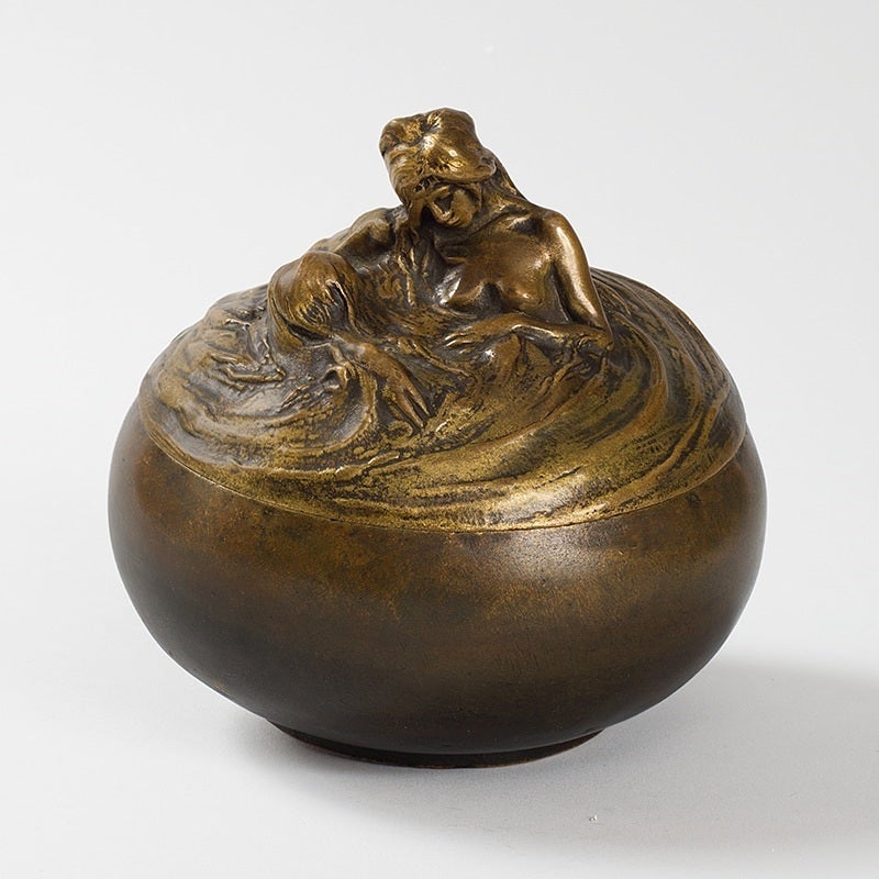 A French Art Nouveau patinated bronze figural covered box by Alexandre Charpentier. The lid of the box is decorated with the head and torso of a nude woman resting in a body of water. 

A similar object is pictured in: The Paris Salons 1895-1915,