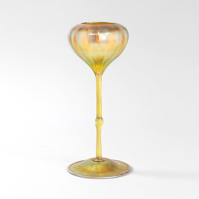 Tiffany Studios flower-form vase featuring gold iridescent glass with ribbed goblet bowl, translucent stem and ribbed foot.  Circa 1905.

A similar vase is pictured in: Tiffany Favrile Art Glass, by Moise S. Steeg, Jr., Atglen, PA: Schiffer, 1997,