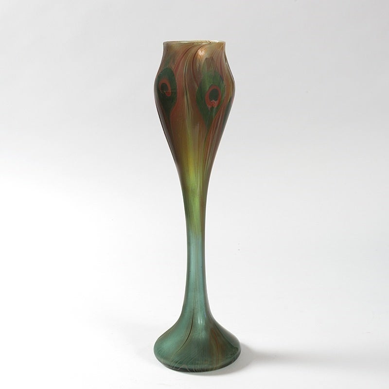 A Tiffany Studios New York rare “Peacock” vase with red/amber and green feather decoration, circa 1896.

A vase with similar decoration is pictured in: The Art Glass of Louis Comfort Tiffany, by Paul E. Doros, New York: The Vendome Press, 2013, p.