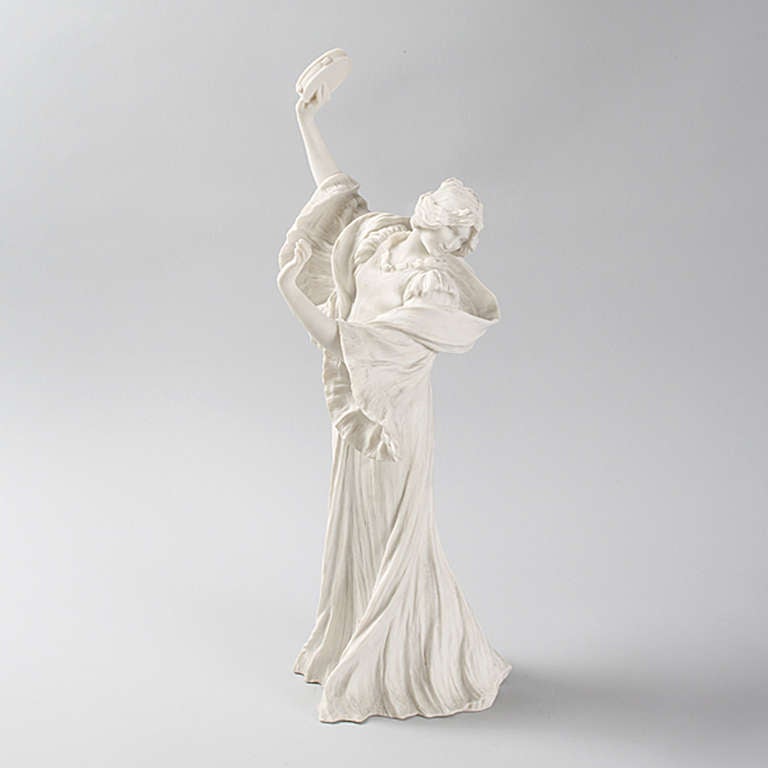 A French Art Nouveau ceramic bisque figural sculpture by Agathon Léonard, featuring a woman dancing with a tambourine, titled “La danse du tambourin tete penchée à gauche