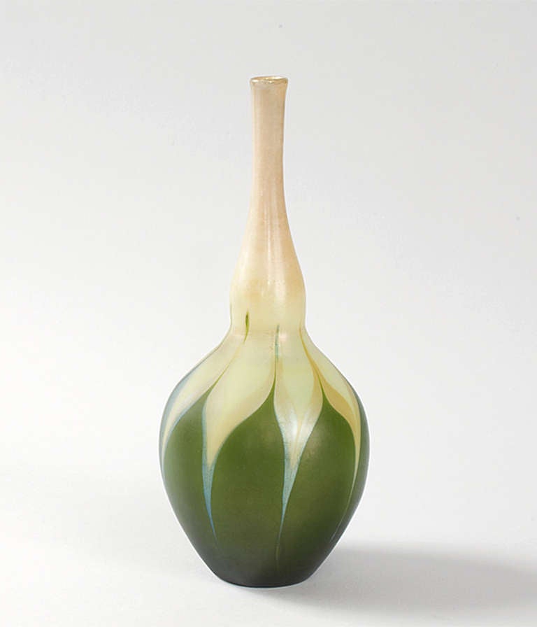 A Tiffany Studios New York  Favrile green and white vase in a gourd form, featuring green and yellow pulled feather decoration and iridescent blue gilt highlights. Circa 1900.

Signed, Signed 