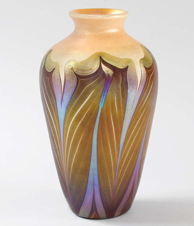 A Tiffany Studios New York Favrile decorated vase.   This vase features pulled copper decoration with iridescent gold trim against a golden ivory ground. Circa 1900.

A vase with similar decoration is pictured in: Louis C. Tiffany: Artist for the